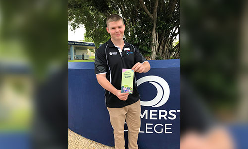 Rohan Kealy holding mental health brochure