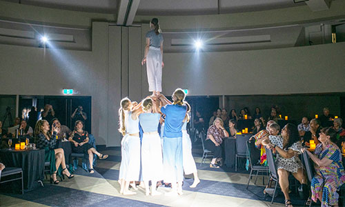 Group of people holding up one person in performing arts